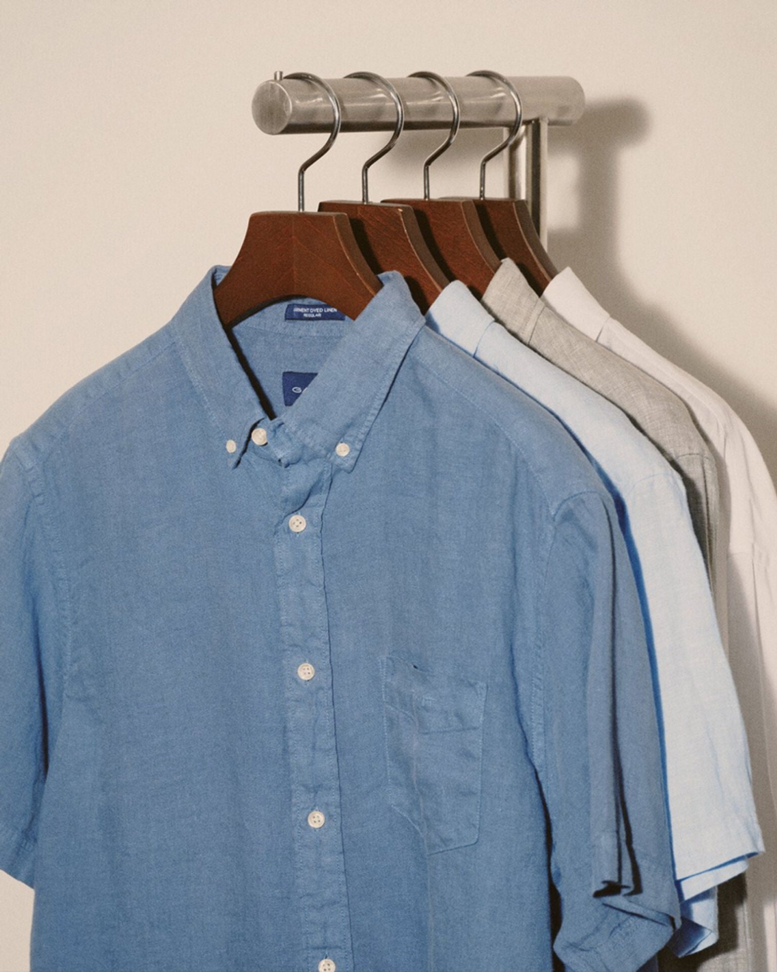 Blue shirt hanging on a rack with other shirts in the background