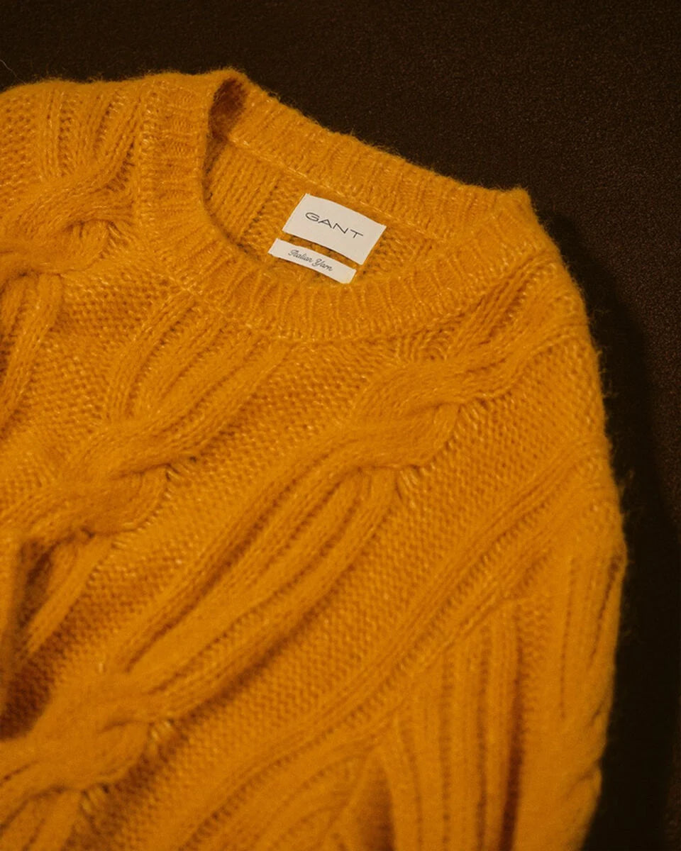 Yellow sweater with Gant label on a dark background