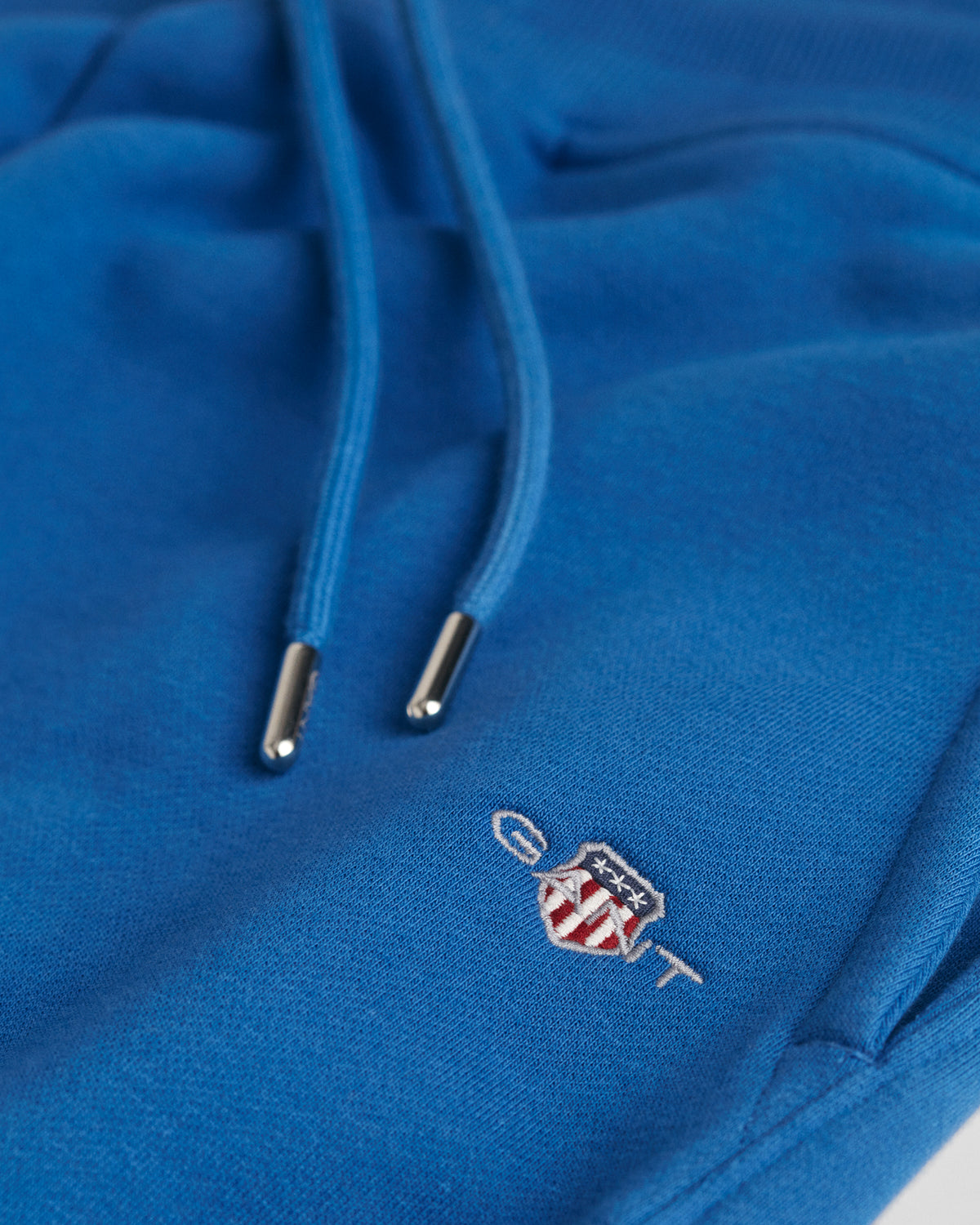 RICH BLUE, REG SHIELD SWEAT SHORTS, FLAT-LAY BY GANT AU.