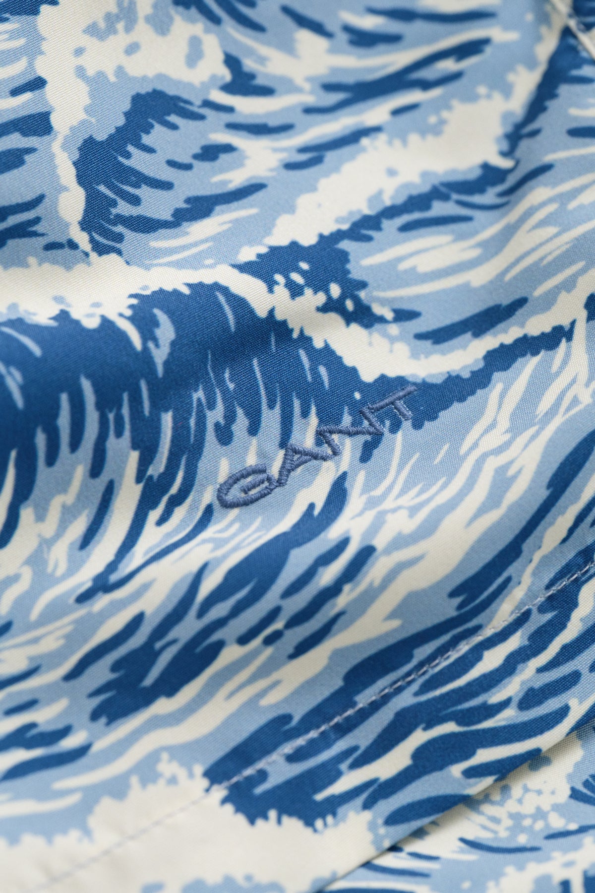 VINTAGE BLUE, WAVES PRINT SWIM SHORTS, FLAT-LAY BY GANT AU.