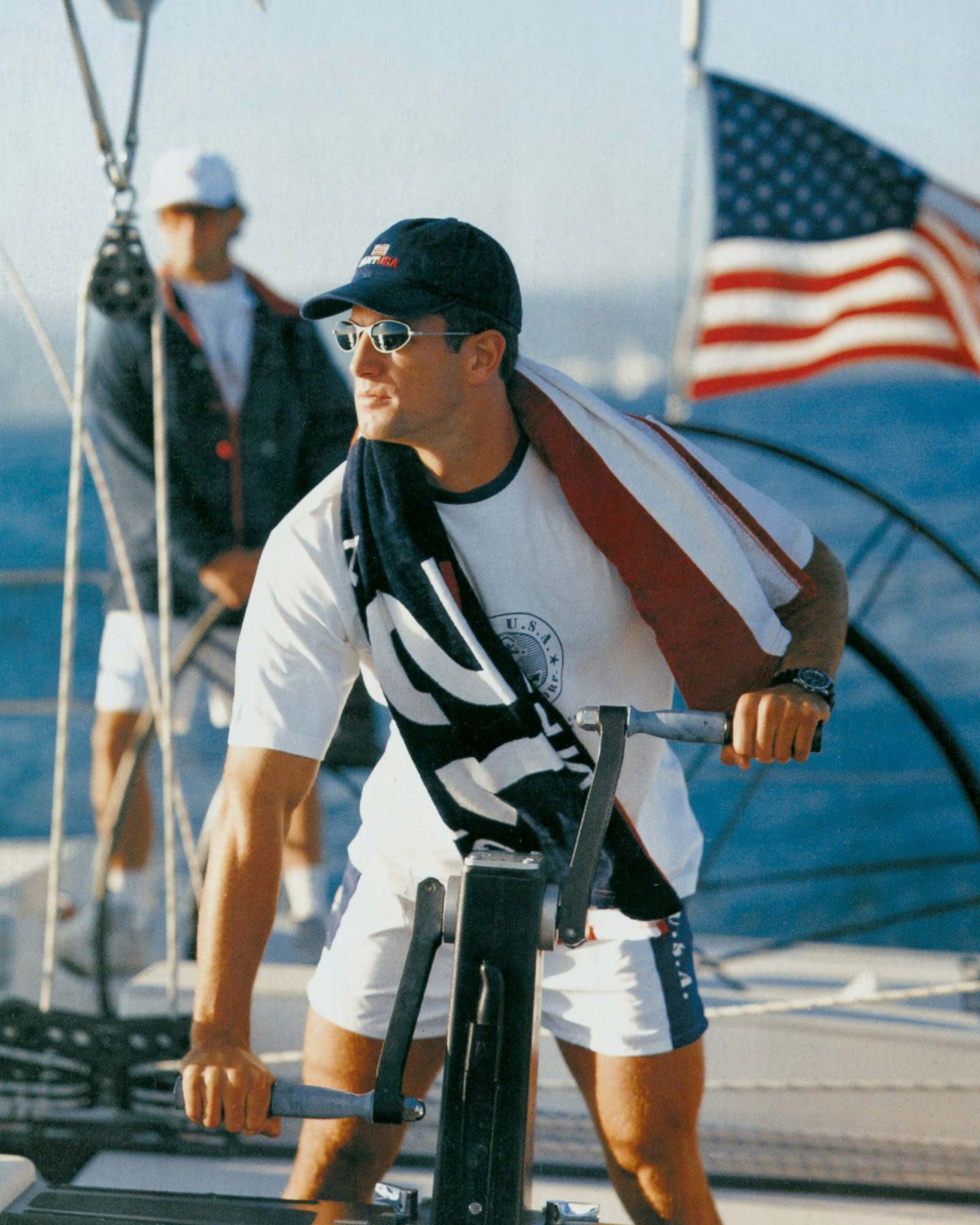 Man exercising on a boat with an American flag in the background